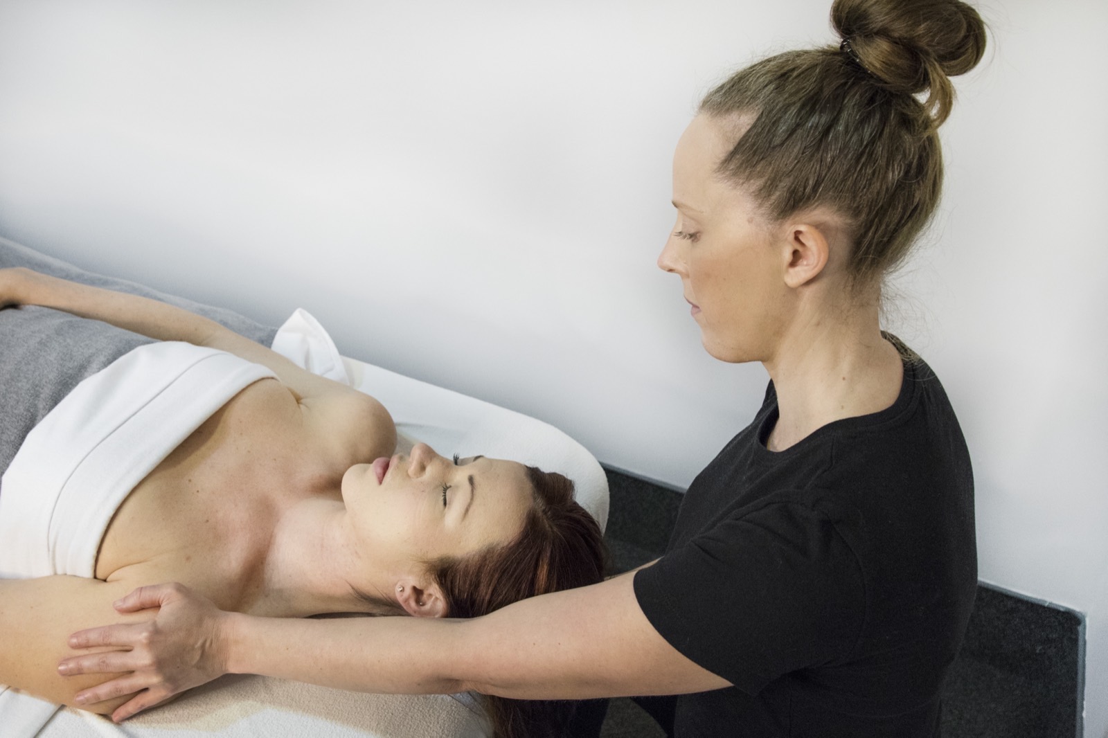 Registered Massage Therapist performing focused therapeutic neck work in a treatment room at Cascade Massage Therapy, South Granville